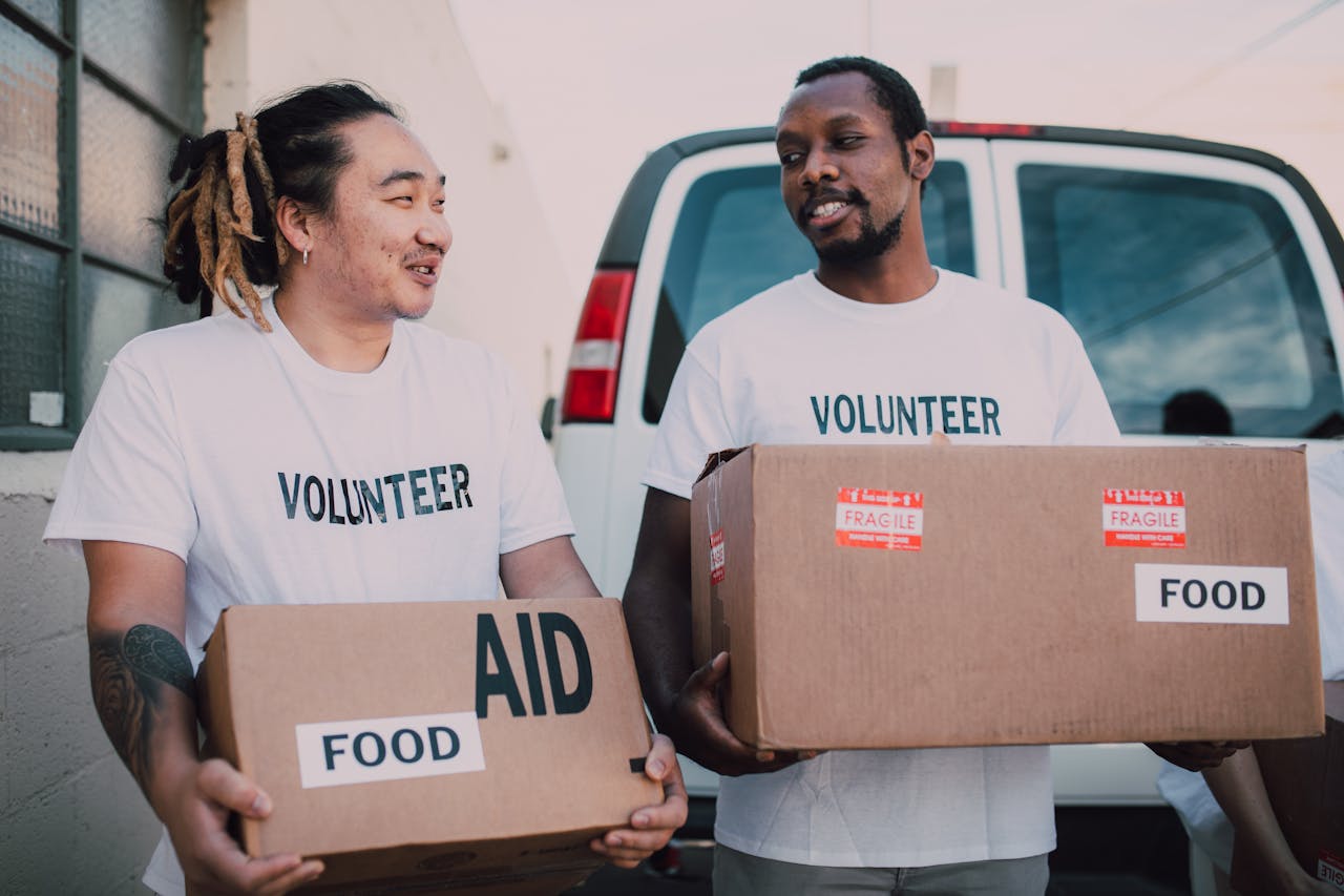 Men Volunteers Carrying Boxes with Relief Goods